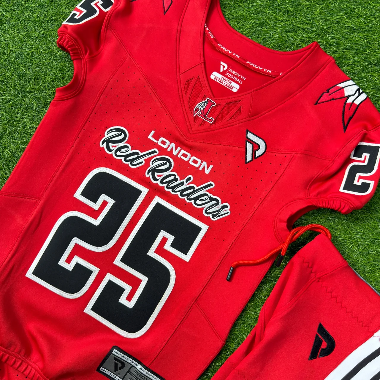 Red London Red Raiders football jersey, number 25, with black and white outlined lettering, PROVYN chest mark and neckline label; matching red pants partially visible on turf